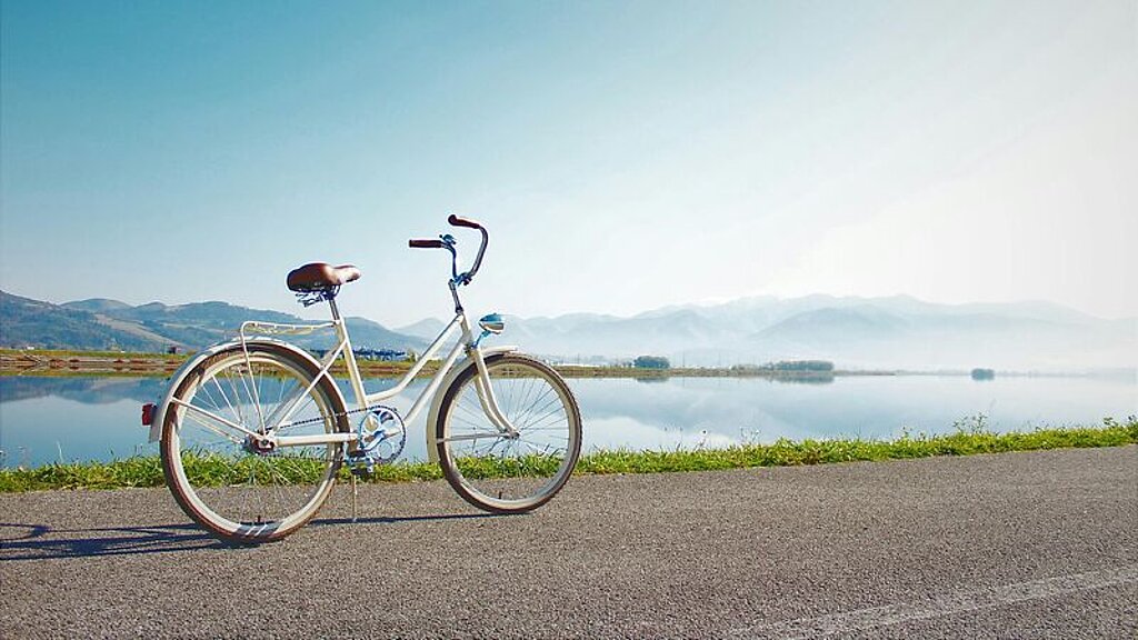 Fahrrad Ein Fahrrad steht geparkt an einem See.