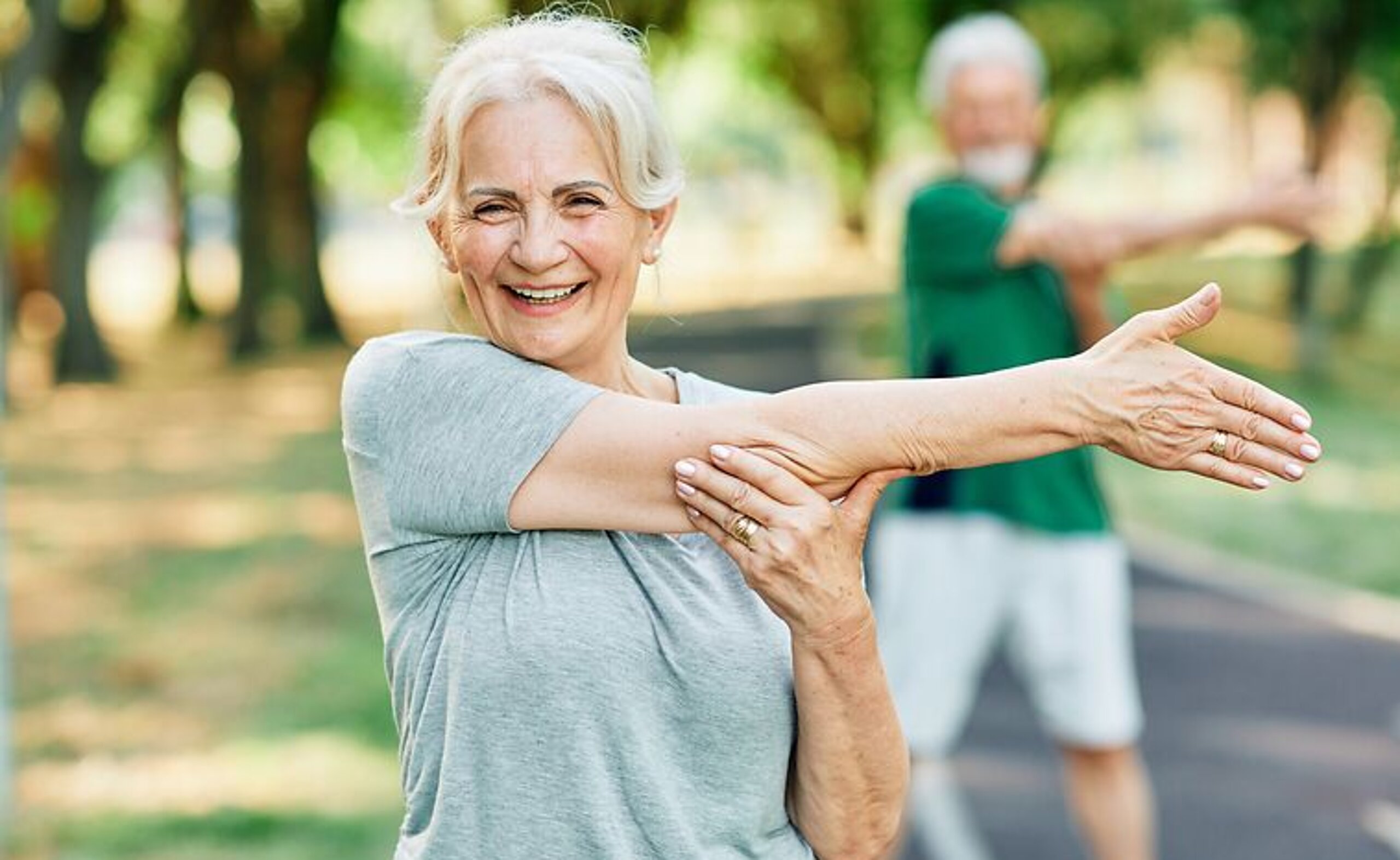 Patientin Gymnastik im Park Frau macht Dehnübungen im Park.